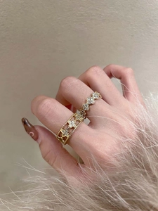 Detailed close-up of double-layer starburst zircon rings with elegant hollow out gold design