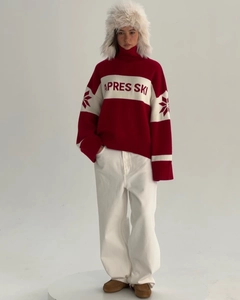 Detail of red and white knit sweater featuring APRES SKI jacquard and snowflake patterns