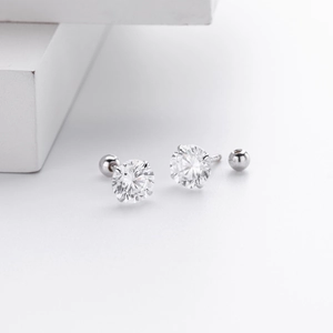 Macro shot of silver stud earrings featuring four-prong cubic zirconia and screw backs