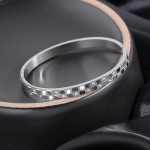 Macro detail of silver waffle pattern bangle with cubic zirconia inlays and hinge clasp