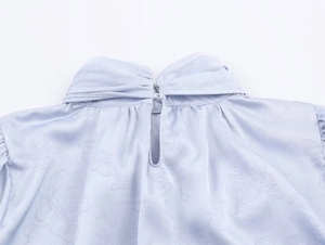 Detailansicht aus hellviolettem Jacquard-Satin mit Knopfverschluss am hinteren Halsausschnitt