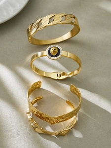 Detailed view of gold stainless steel lion head bangle with hammered texture and zircon stones
