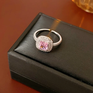 Macro detail of crown ring with square pink zircon and pave crystals on black box