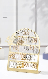 Detail of a minimalist gold iron jewelry rack with 56 holes for hanging earrings