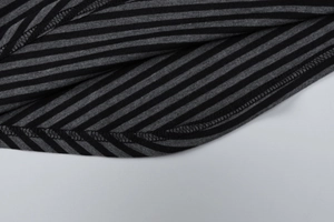 Macro shot of striped knitted fabric with high-quality hem stitching on a gray shirt