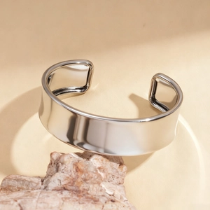 Minimalist wide open cuff bracelet in silver with a polished mirror finish on rock base