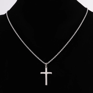 Dettaglio del ciondolo a croce d'argento con catena a fune su espositore nero per collo
