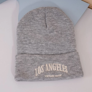 Gros plan de la broderie LOS ANGELES VINTAGE MADE sur un bonnet en tricot gris