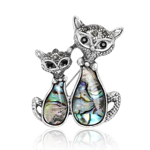 Detailed view of cat couple brooch featuring iridescent abalone shell and crystals