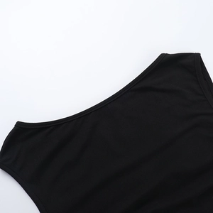 Dettaglio della trama in maglia a coste sullo scollo di un top nero con cut-out