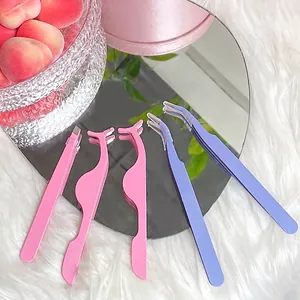 Pink and purple eyelash tweezers for fake lash application on reflective surface