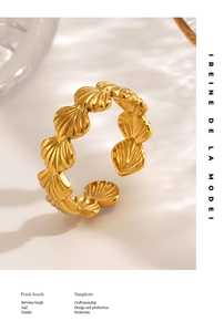 Detailed close-up of golden stainless steel shell ring with polished metallic texture