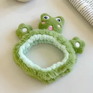 Détail du bandeau grenouille en peluche verte avec élastique pour le soin du visage