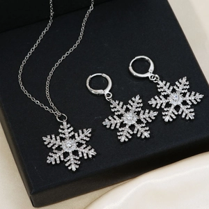 Sparkling silver snowflake necklace and earrings set with zircons in a black gift box