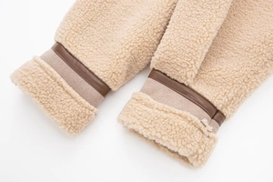 Detail of shearling cuffs with brown leather trim and high-density stitching on the jacket