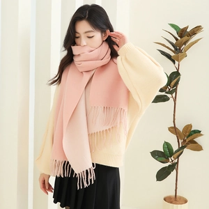 Detail of pink and beige double-sided scarf showing soft knit texture and fringe edge