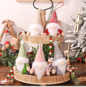 Set of five handmade Christmas gnomes with glitter stars on a tiered wooden tray