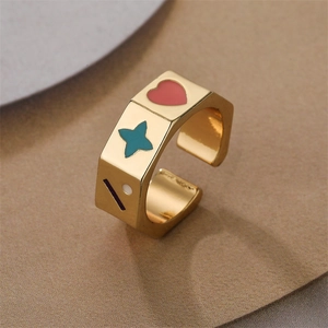 Macro shot of gold-plated open ring with heart and star enamel details