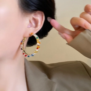 Elegant C-shaped hoop earrings with colorful rainbow beads and silver needles on model