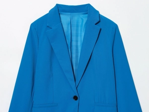 Détail d'un blazer bleu chic avec revers crantés et fermeture à bouton unique