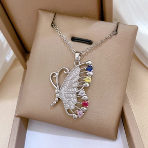 Detail view of silver butterfly necklace with colorful teardrop stones in a jewelry box