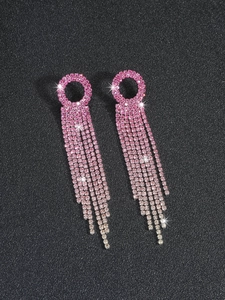 Macro detail of sparkling pink gradient rhinestone long tassel earrings on black background