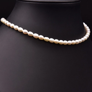 Close-up of natural oval freshwater pearls with high luster on black display stand