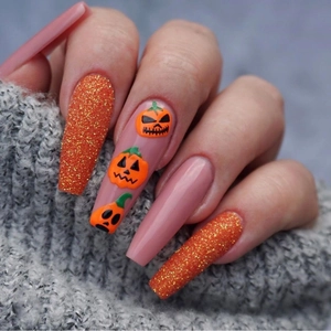 Unghie finte Halloween con glitter arancioni 3D e motivi zucca su forma a bara lunga
