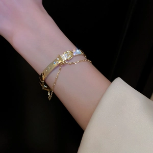 Detailed view of gold-plated belt buckle bracelet with pavé cubic zirconia and opal stones