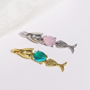 Detailed view of fish-shaped pendants in silver and gold with colorful gemstones