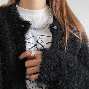Close-up of 925 sterling silver heart ring and beaded necklace worn by a fashion model