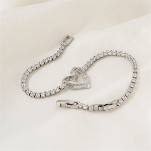 Silver heart tennis bracelet with clear zircon stones on a soft white satin background