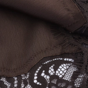 Close-up of dark brown ribbed knit fabric joined with delicate lace trim detailing