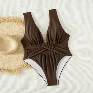 Solid deep brown one-piece V-neck swimsuit with twist waist and beach hat flat lay