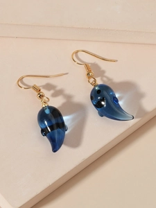 Detailed close-up of translucent blue resin ghost pendant earrings with gold hooks