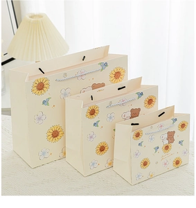 Three sizes of sunflower and bear gift bags with ribbon handles and floral patterns