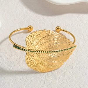 Gold leaf shaped open cuff bracelet with green crystals in polished stainless steel