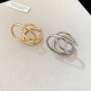 Minimalist gold and silver double-layered geometric ear cuffs set on woven background