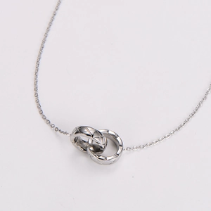 Macro detail of silver interlocking rings necklace featuring an engraved quilted pattern