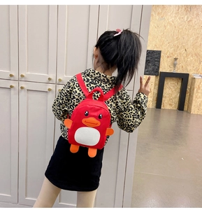 Rear view of a child wearing a cute 3D red cartoon duck backpack for kindergarten kids