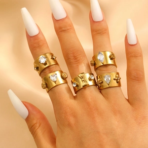 Detailed view of five gold-toned stainless steel rings set with various zircon stones