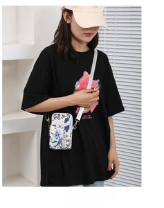 Detail of floral Oxford fabric phone crossbody bag with adjustable silver strap and zipper