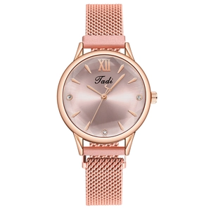 Gros plan sur la montre rose dorée avec bracelet en maille et cadran rose élégant