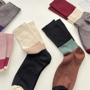 Detail of ribbed knit cashmere crew socks featuring various colorful striped patchwork designs