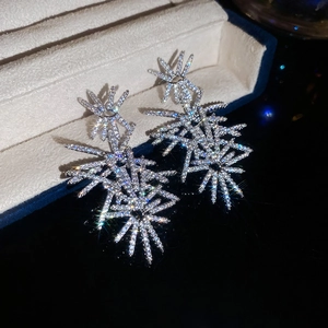 Close-up of silver-toned firework stud earrings with micro-set cubic zirconia on velvet