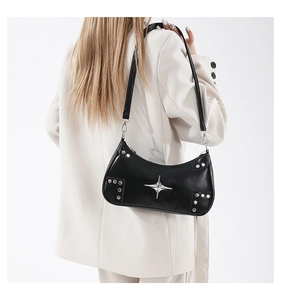 Detailed back view of black rivet shoulder bag with silver star studs on a beige blazer
