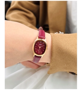 Gros plan d'une montre femme GEDI ovale en or rose avec cadran et bracelet en cuir rouge