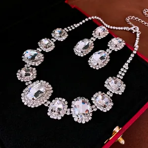 Elegant silver oval crystal necklace and earring set displayed in a black jewelry box