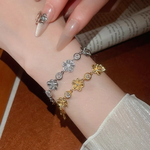 Détail de bracelets en forme de fleur dorés et argentés avec incrustation de zircons