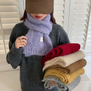 Detail showing various colors of knitted bow skinny scarves in purple, red, and beige